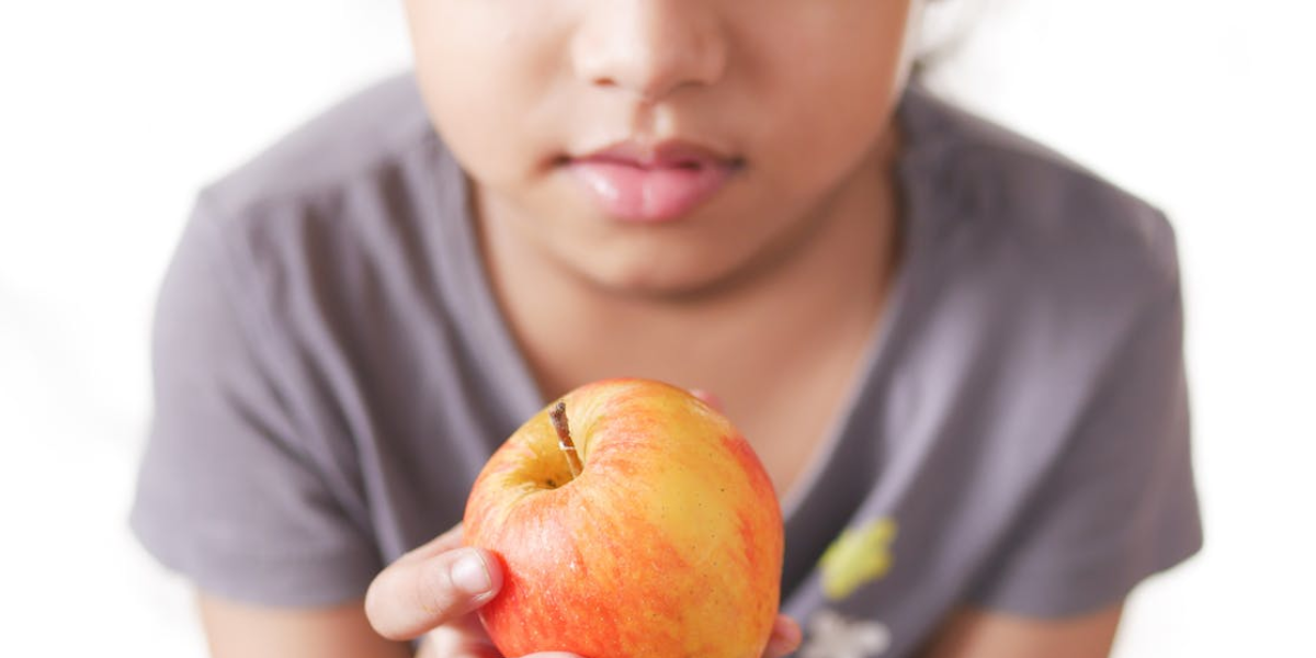 Little girl holding a red apple