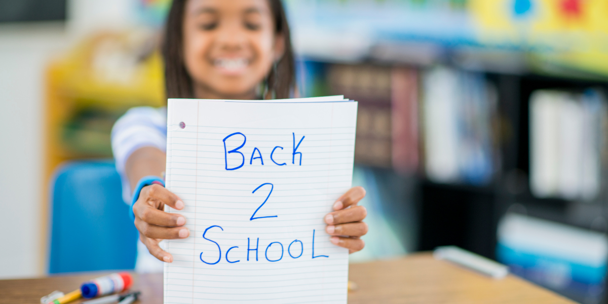 Young woman holding a sign that says Back to School