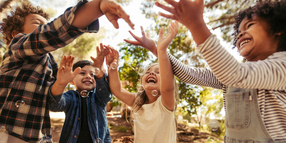 Group of toddlers outside playing with bubbles