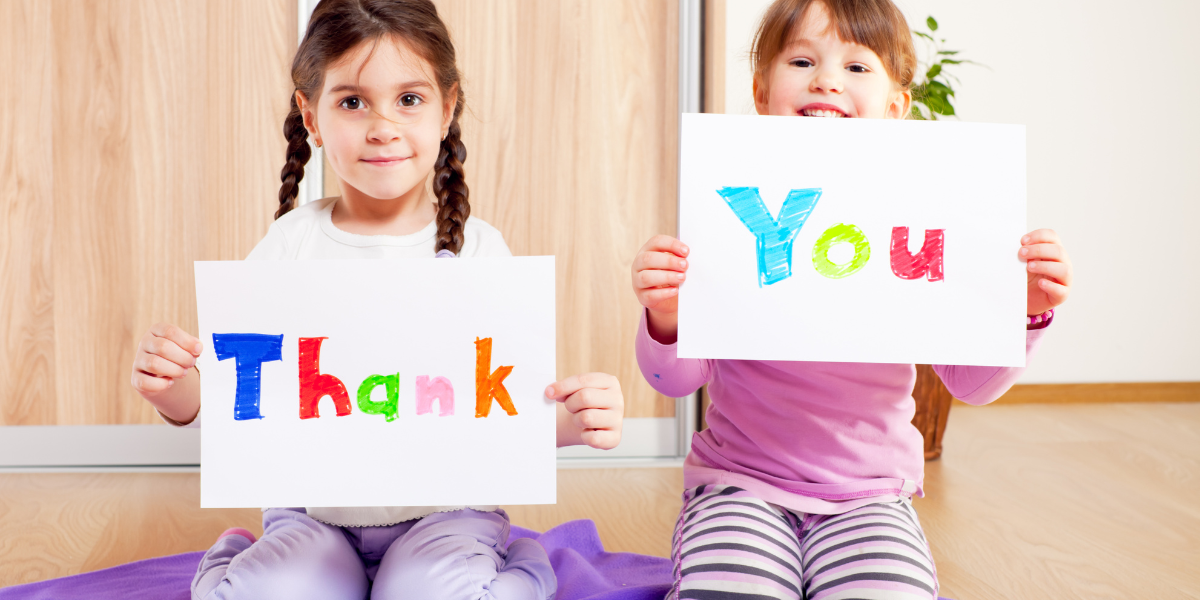 Children holding up signs that say thank you