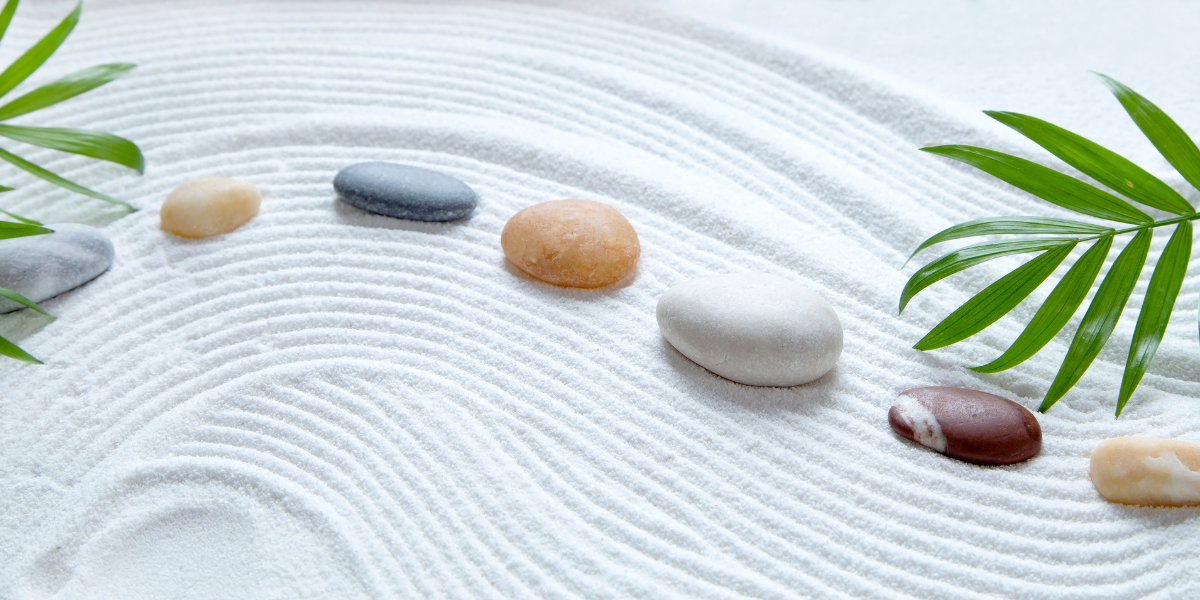 A Zen garden with sand, rocks, and leaves