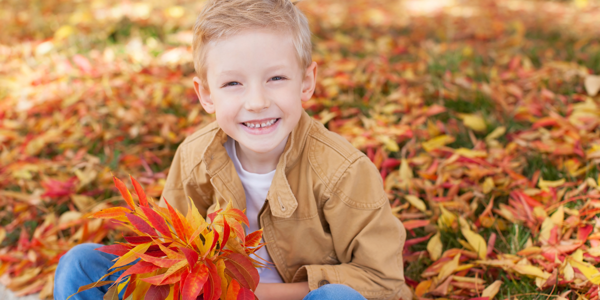Young boy playing in a field of leaves