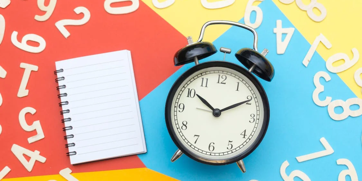 Picture of a clock, a notebook, and numbers for teaching how to tell time