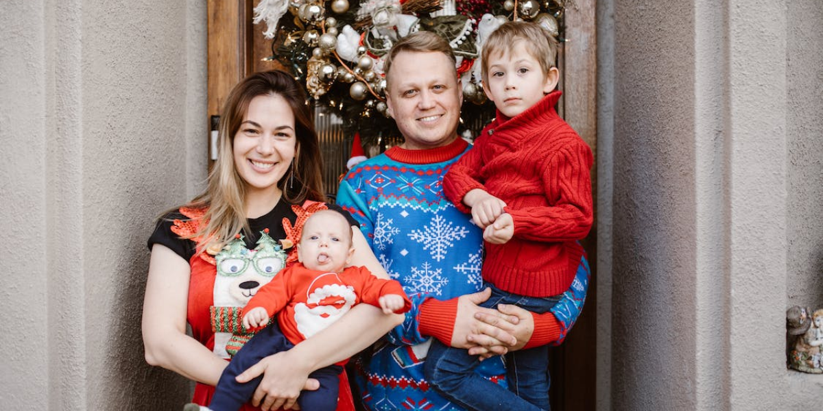 A family wearing "ugly" Christmas sweaters poses for a family portrait. 
